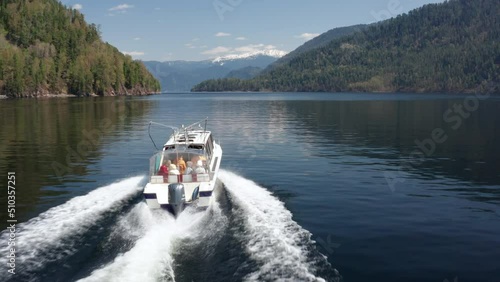 A pleasure boat goes along a picturesque lake on a sunny summer day
