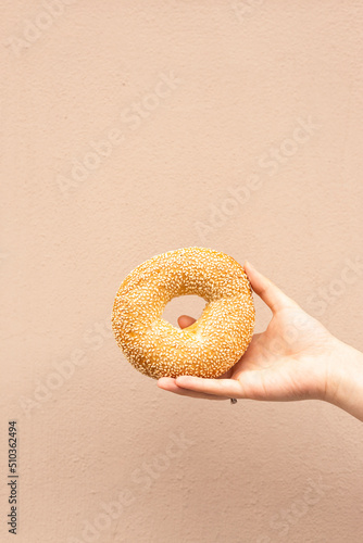 delicious fresh bagel in girl's hand