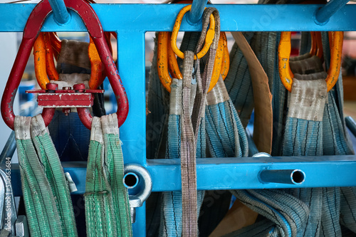 Rigging equipment with strops hangs on rack in warehouse photo