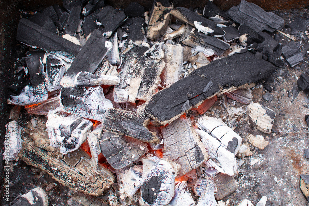 Barbecue grill with glowing and flaming hot charcoal briquettes, close-up Barbecue grill with glowing and flaming hot charcoal briquettes, close-up