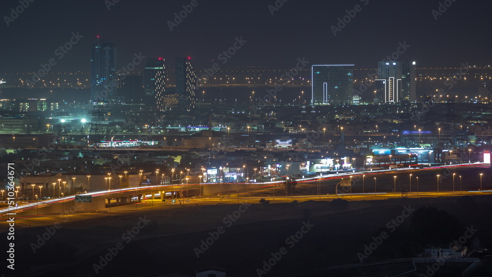 Dubai skyline with villa houses and construction site of new towers on a background aerial night timelapse.