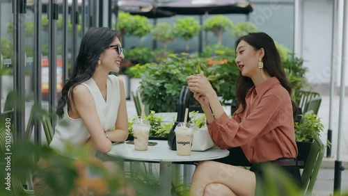 happy girlfriends sit chat on the outdoor cafe