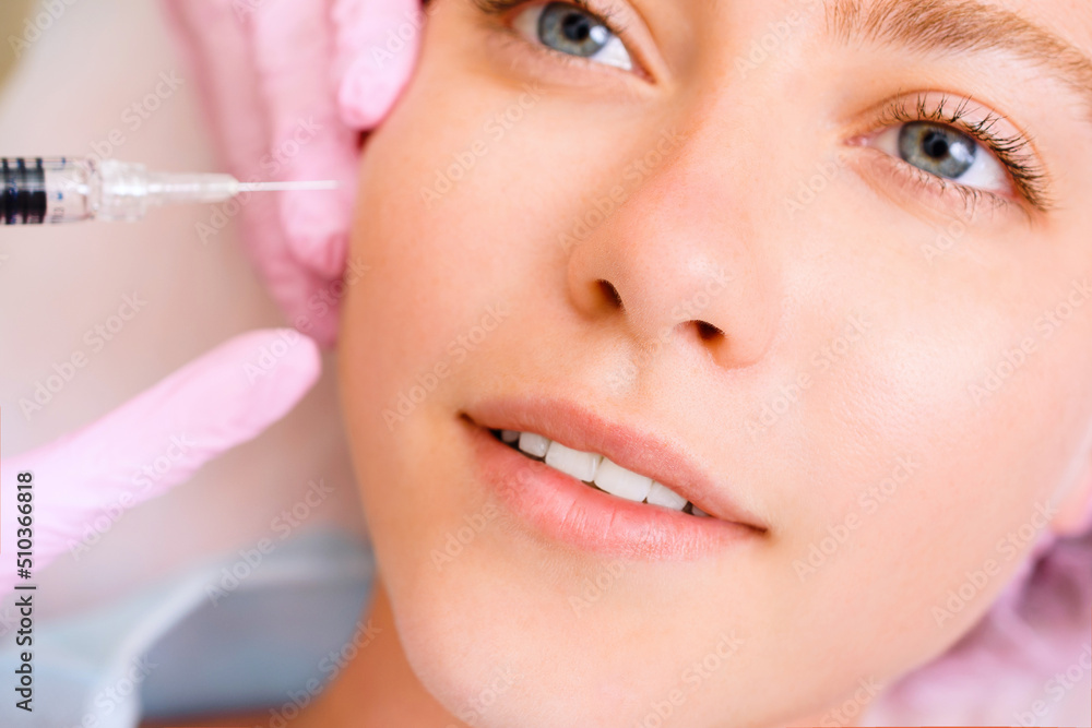 Image of a young beautiful woman dressed as a patient, lying on a couch in a cosmetology clinic.