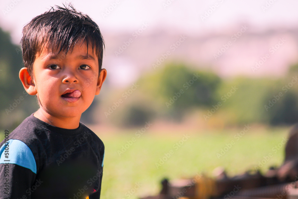 Indian boy sticking out his tongue,beautiful indian baby boy in pomegranate garden, Indian boy sticking out his tongue,beautiful indian baby boy in pomegranate garden,