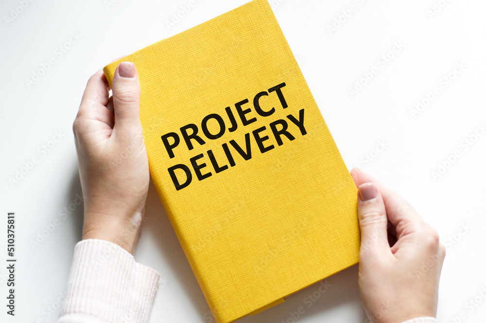 Closeup on businessman holding a card with text PROJECT DELIVERY, business concept image with soft focus background and vintage tone Closeup on businessman holding a card with text PROJECT DELIVERY, business concept image with soft focus background and vintage tone