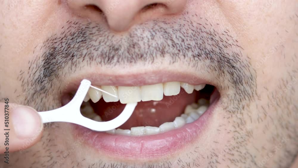 close up4 k video man's mouth smiling and flossing his teeth with a