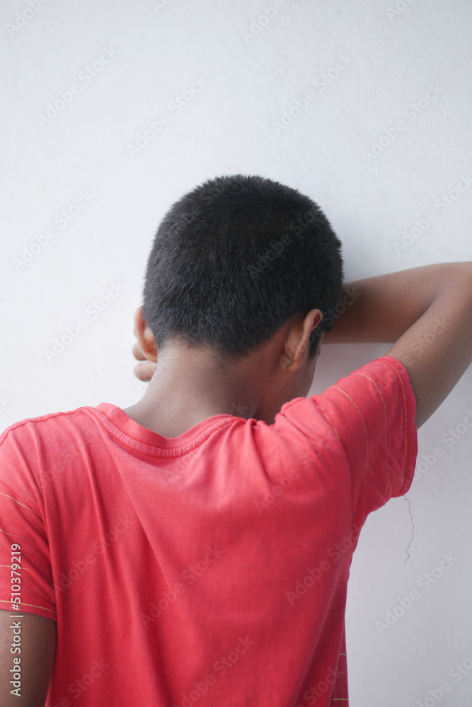 sad child hiding her face on wall sad child hiding her face on wall