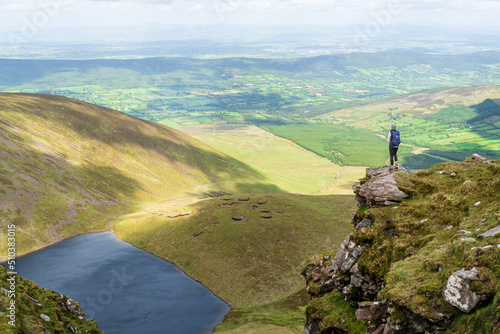 Successful hiker on the mountain top enjoying the view over a lake.
View from Galtee Mountains overlooking lake Curra in Tipperary, Ireland.