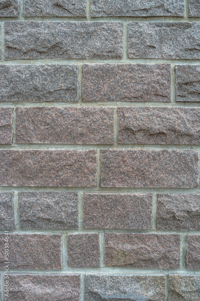 Obraz premium Cover page with modern granite stone wall with patterns of bricks and stones as a background, closeup, details.