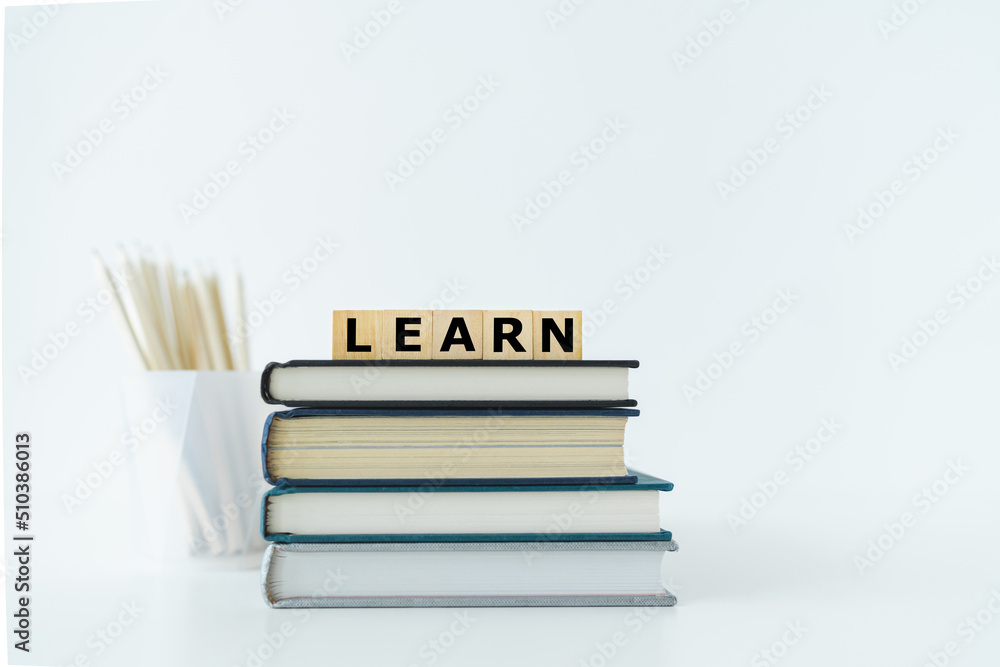 Book or textbook stack and pencil with word LEARN. Skill improvement for student or businessperson. Studying and training course online at home. Business success idea, education learning concept Book or textbook stack and pencil with word LEARN. Skill improvement for student or businessperson. Studying and training course online at home. Business success idea, education learning concept
