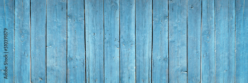 blue fence made of old wooden boards, texture and structure of wooden boards close-up banner, background for design