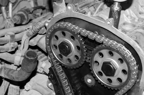 View of the camshaft gears of the timing chain drive of an automobile engine with the front cover removed. Black and white photo