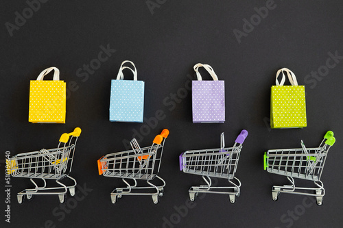 Small paper shopping bags with shopping cart on black background