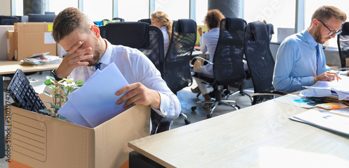 Tableau sur toile Sad dismissed worker are taking his office supplies with him from office