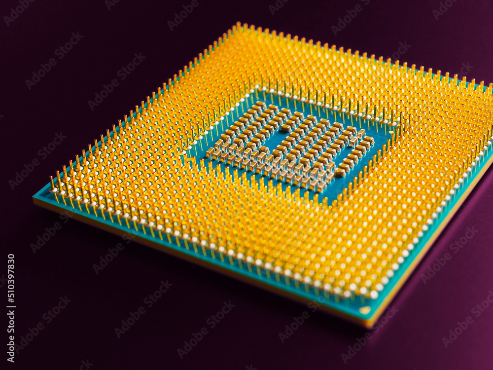 Computer hardware. Processor lies on dark violet matte surface. CPU, semiconductors, pins and connectors. Illustration: electronic and computing equipment. Semiconductor and microprocessor. Macro Computer hardware. Processor lies on dark violet matte surface. CPU, semiconductors, pins and connectors. Illustration: electronic and computing equipment. Semiconductor and microprocessor. Macro