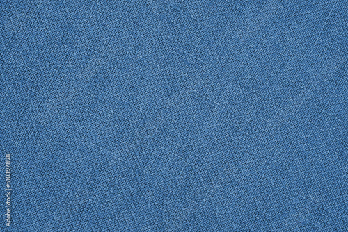 Blue woven surface close-up. Linen textile texture. Graceful color fabric background. Textured braided backdrop or wallpaper. Macro