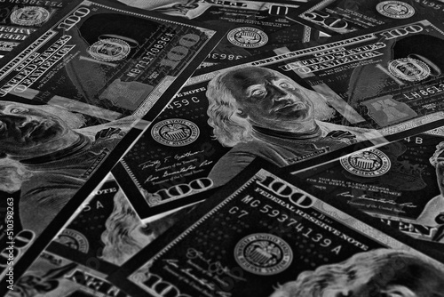 American paper money. 100 dollar and other US bills. Black and white background or wallpaper. Savings economy and the USA dollar. Dark inverted photos. National debt and Treasury