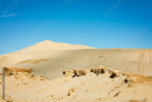 Desert-like landscape of the Giant sand dunes, Te Paki, on a beautiful summer day. Bizzarre sand formations and classic cones under clear blue sky. Northland, New Zealand photo