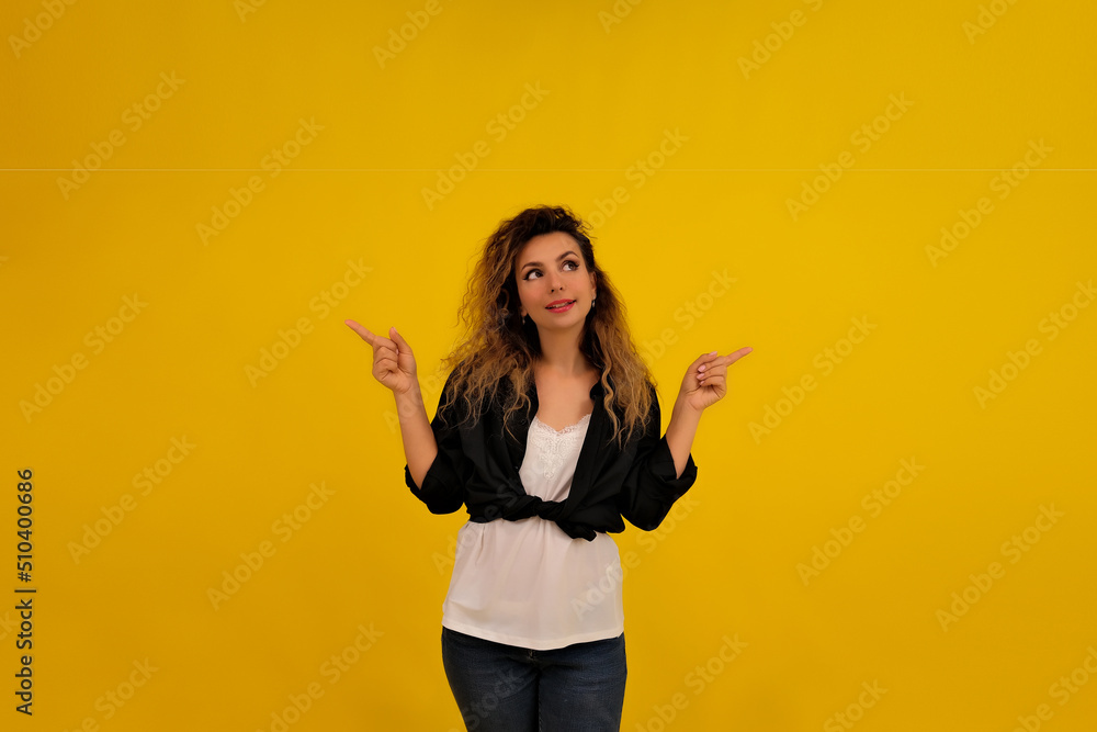 Close-up portrait of a beautiful girl on a yellow background. woman shows you need to look. the points above, shows a brand new product, advertises copy space Close-up portrait of a beautiful girl on a yellow background. woman shows you need to look. the points above, shows a brand new product, advertises copy space
