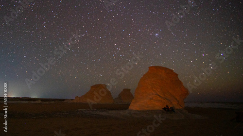 amazing night sky in the white desert in Egypt with countless stars in the sky and beautiful rock formations in the foreground photo