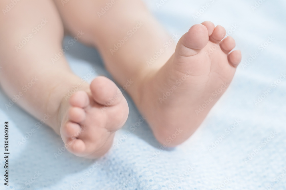baby legs lie on a blue blanket. Baby health. Leg motor skills baby legs lie on a blue blanket. Baby health. Leg motor skills