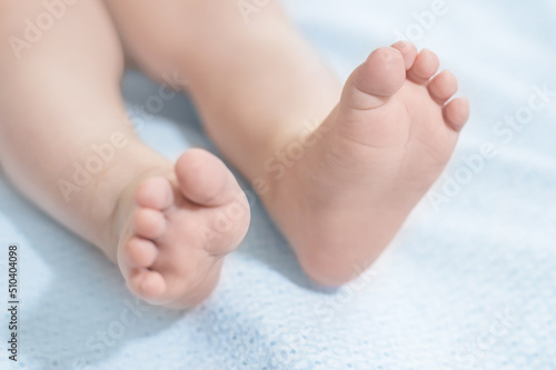 baby legs lie on a blue blanket. Baby health. Leg motor skills © Evgenia