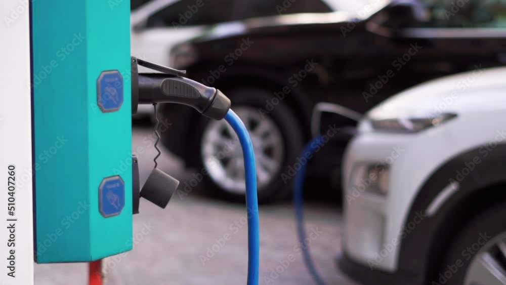 Close up of a device for charging electric cars. Renewable energy. Saving ecology. Electric car charger at the parking Close up of a device for charging electric cars. Renewable energy. Saving ecology. Electric car charger at the parking