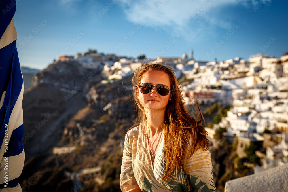 The woman in sunglasses on Santorini island during sunset. Vacation in Greece. The woman in sunglasses on Santorini island during sunset. Vacation in Greece.
