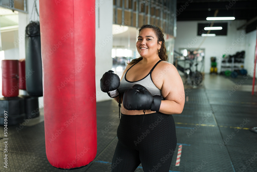 Happy fat woman using boxing gloves