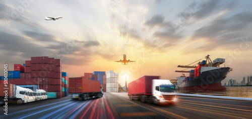 Container truck in ship port for business Logistics and transportation of Container Cargo ship and Cargo plane with working crane bridge in shipyard at sunrise, logistic import export and transport 