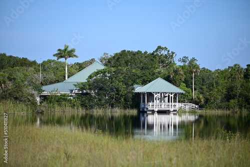 Ernest F Coe Visitor Center at entrance to Everglades National Park, Florida reflected in calm pond on sunny summer morning.