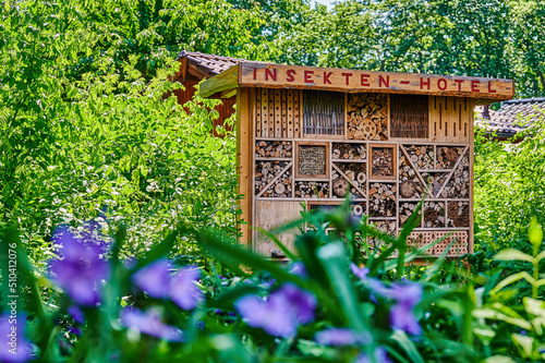 View to an insect hotel made of different materials to offer a retreat for many species. The text above is German for insect hotel.