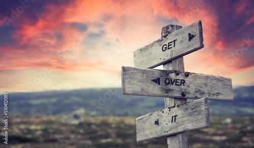 Foto get over it text quote caption on wooden signpost outdoors in nature with dramatic sunset skies