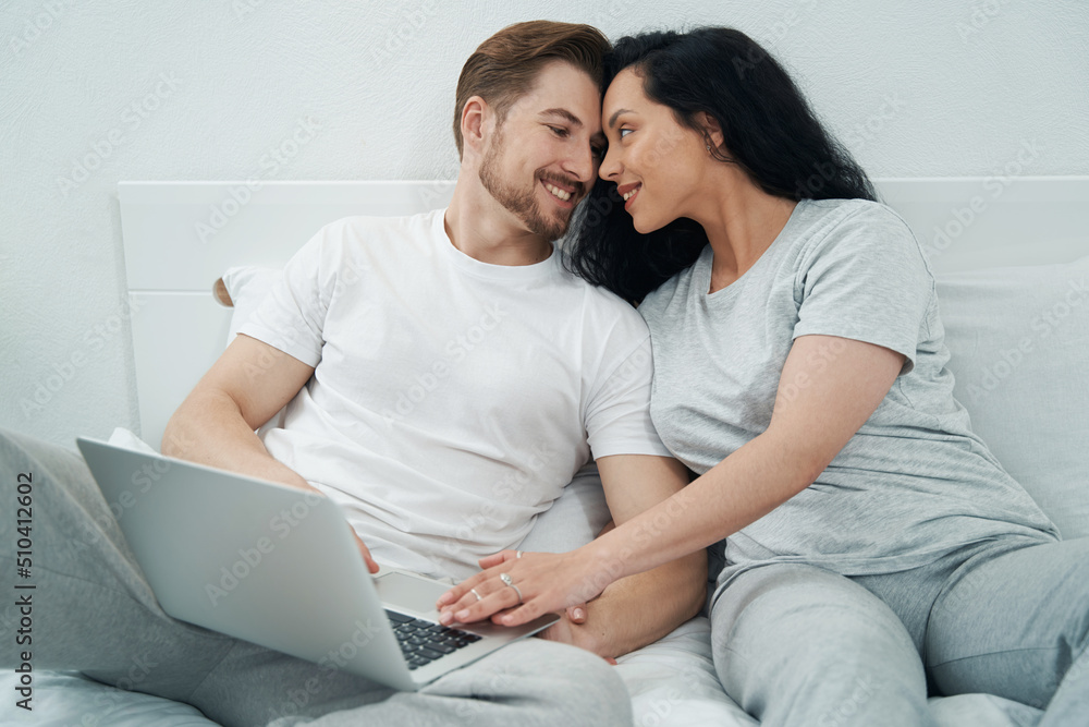 Man in love and his joyous female companion in bedroom Man in love and his joyous female companion in bedroom
