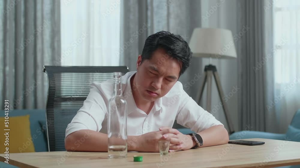 Drunk Asian Man With Vodka And Smartphone On Table Looking At Camera At Home
Drunk Asian Man With Vodka And Smartphone On Table Looking At Camera At Home