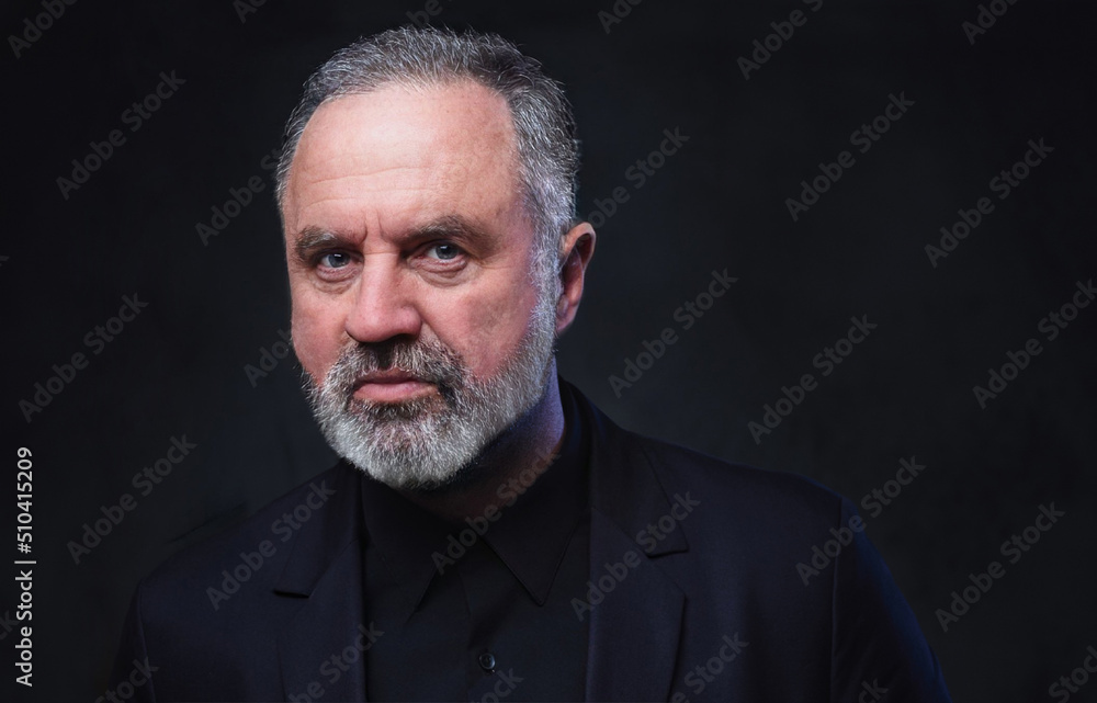 Studio shot of stylish aged man with beard dressed in black coat and black shirt. Studio shot of stylish aged man with beard dressed in black coat and black shirt.