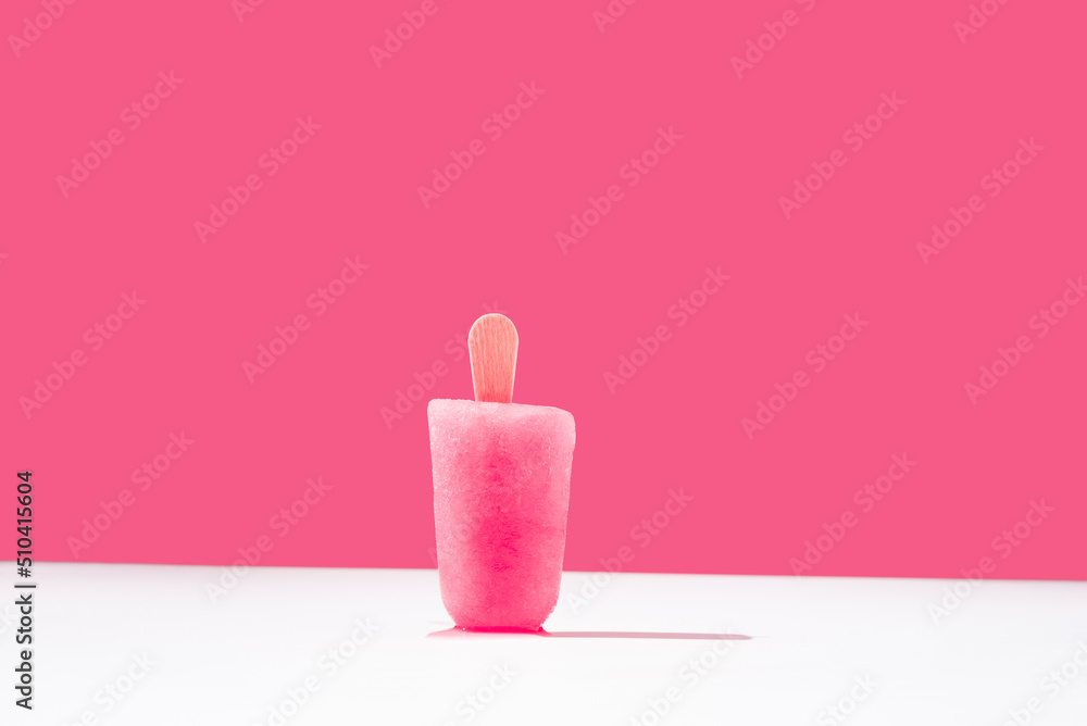 Paleta de hielo con sabor a frambuesa en pie sobre una mesa blanca. Palo de helado rosa. Espacio para texto Paleta de hielo con sabor a frambuesa en pie sobre una mesa blanca. Palo de helado rosa. Espacio para texto