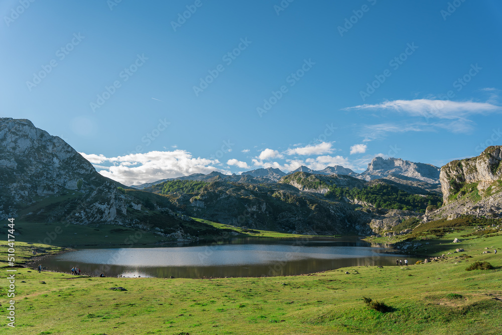 Beautiful lake surrounded by mountains and green meadows