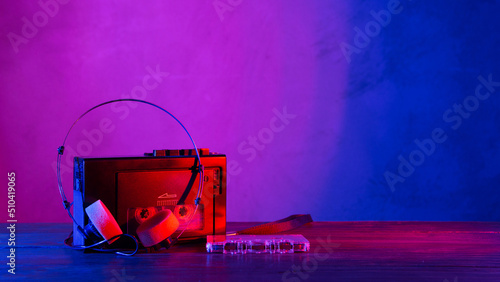 Vintage cassette tape player in neon light. 80s - 90s advertisement style. Disco party nostalgy concept