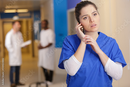 Canvas Print concerned female doctor in uniform talking on the phone