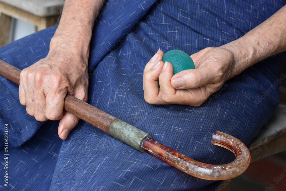  Asian elder man gripping hand exercise elastic ball.