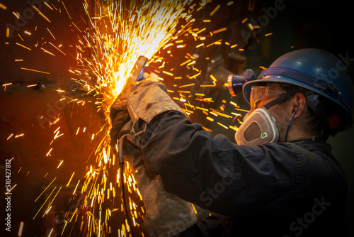 Canvas Print The worker polished the metal splashing sparks