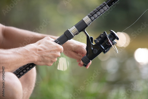 fisherman reeling in the line on his fishing rod