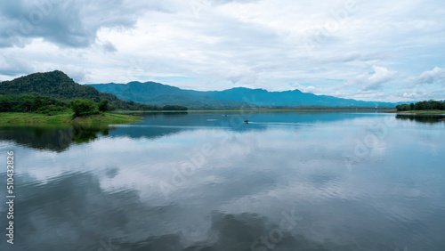 The natural view of the Malahayu reservoir. A water area in the form of a beautiful lake connected by many rivers. There are several fishing boats and the weather is cloudy.