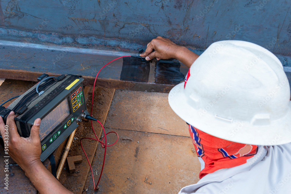 Inspectors are checking defects in welded steel h-beam add joint with ...
