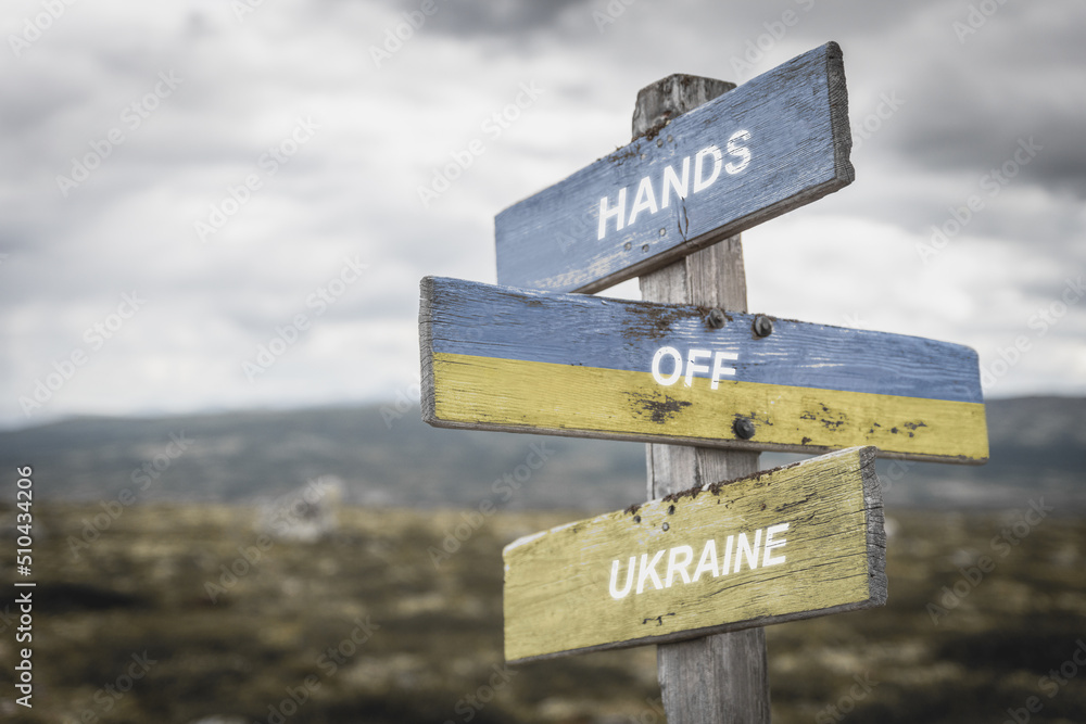 hands off ukraine text quote on wooden signpost outdoors in nature. War in ukraine concept.