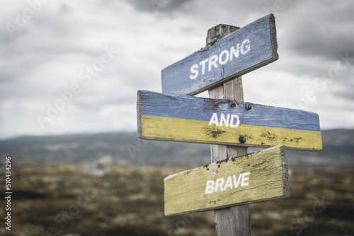 Canvas Print strong and brave text quote on wooden signpost outdoors in nature