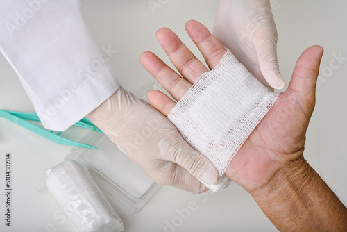 Fototapete Doctor doing wound dressing care and bandaging patient's hand, Hand surgery treatment, Nurse treat patient's finger injury in hospital