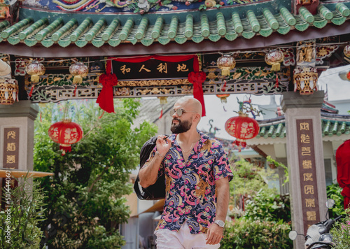 Young man with a backpack on the background of an asian temple