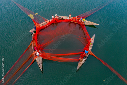 Local fishermen are fishing in river with huge net. Aerial View taken with drone. photo